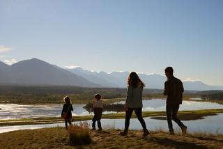 A family walk through a sandy, mountainous waterbank