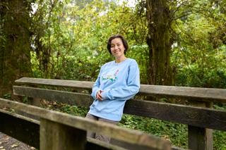 Dr. Tse-Lynn Loh in her wildflower apparel relaxing on a foot bridge in Keswick Park in Burnaby.