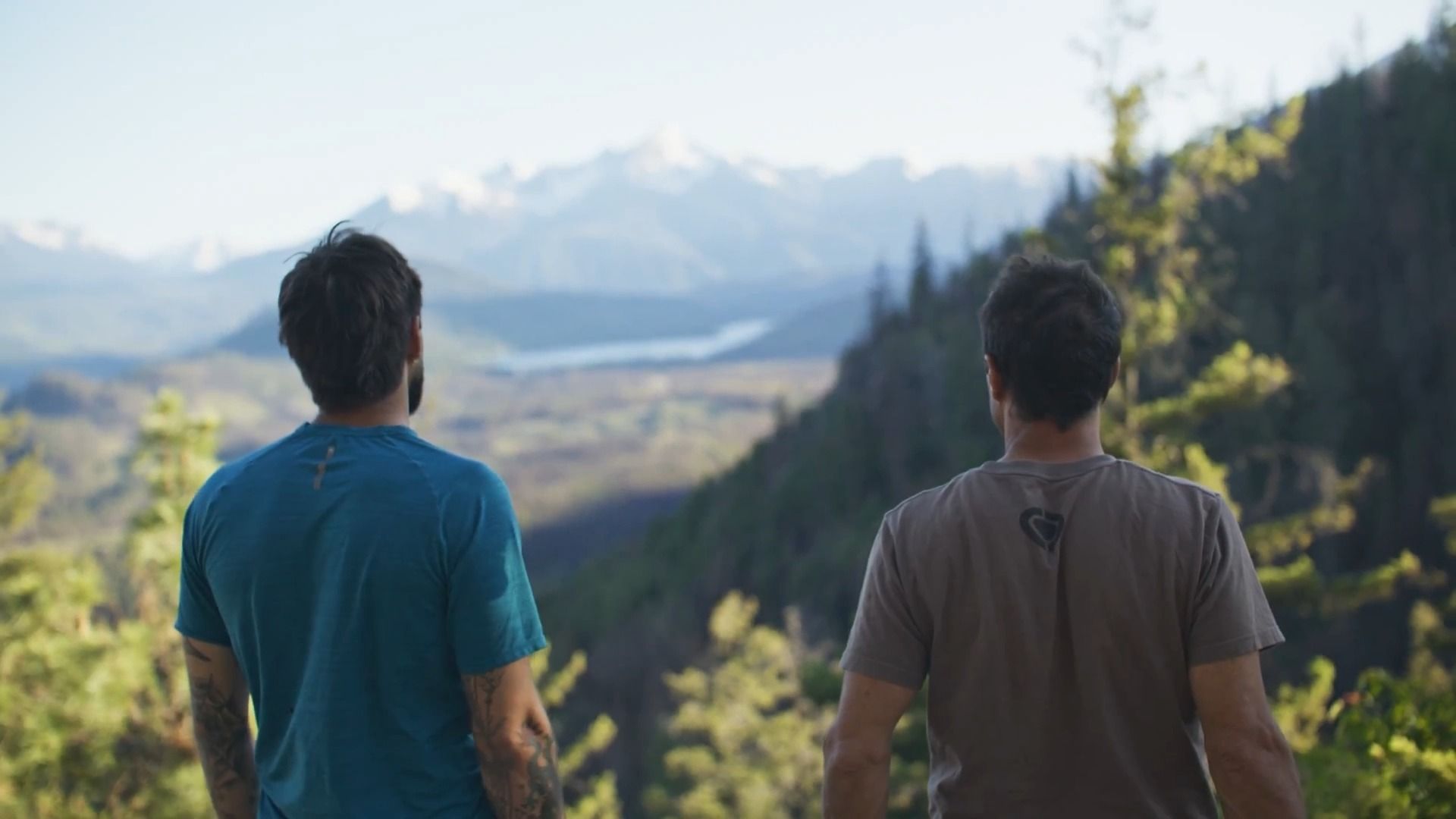 Two people look out across a mountainous scene