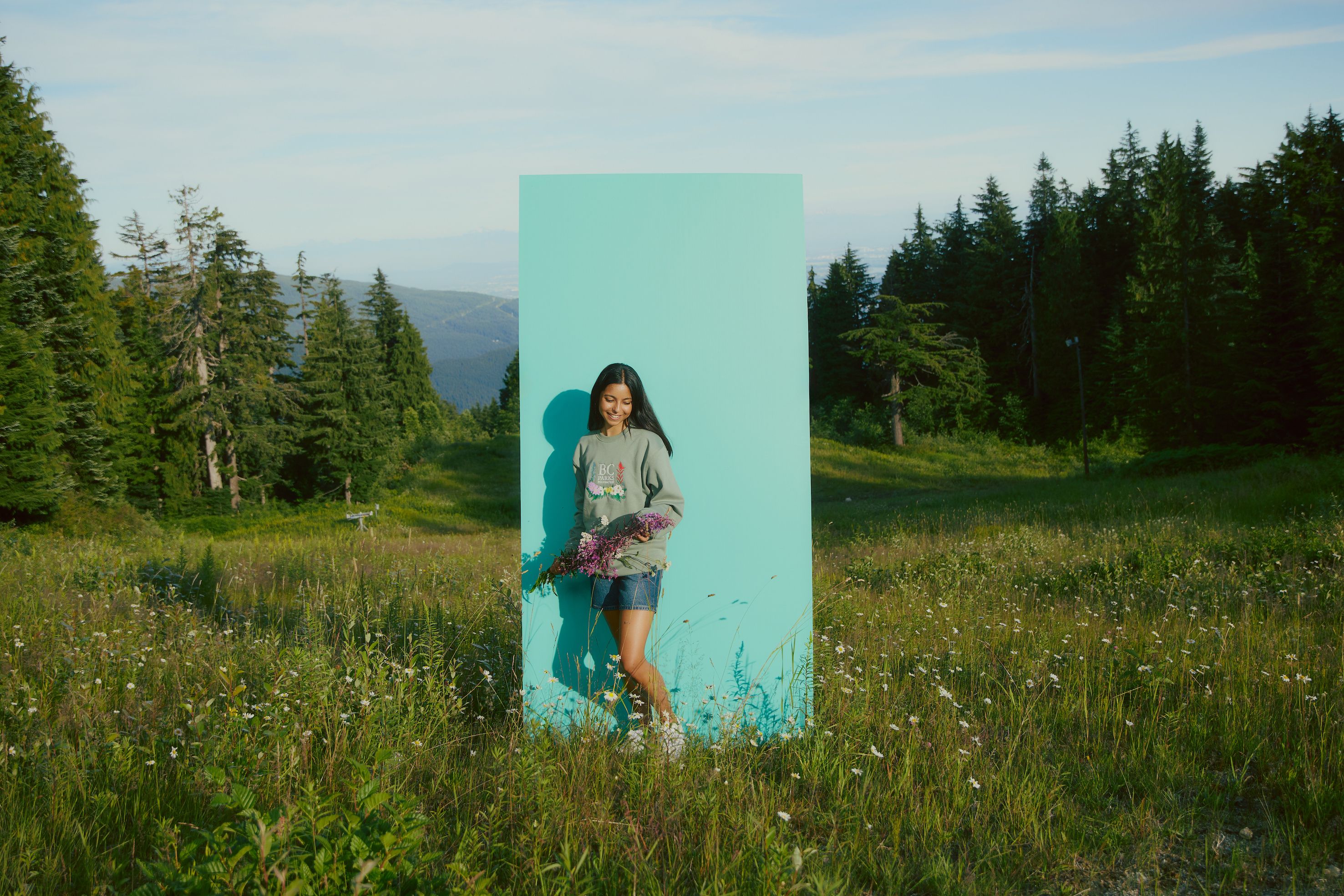 Person wearing BC Parks Foundation Wildflower Collection stands in meadow