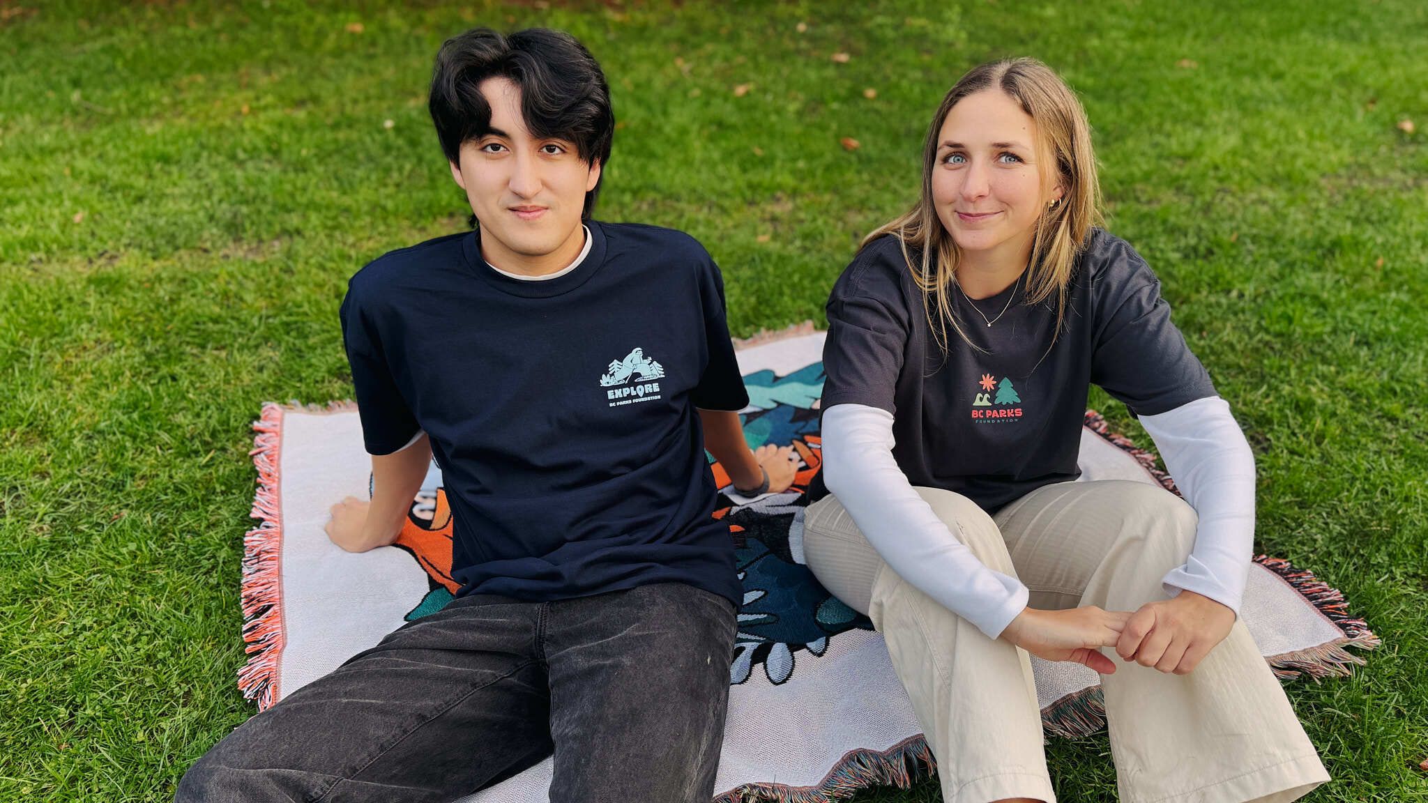 Two people wearing Turbo Bambi merch sit on blanket