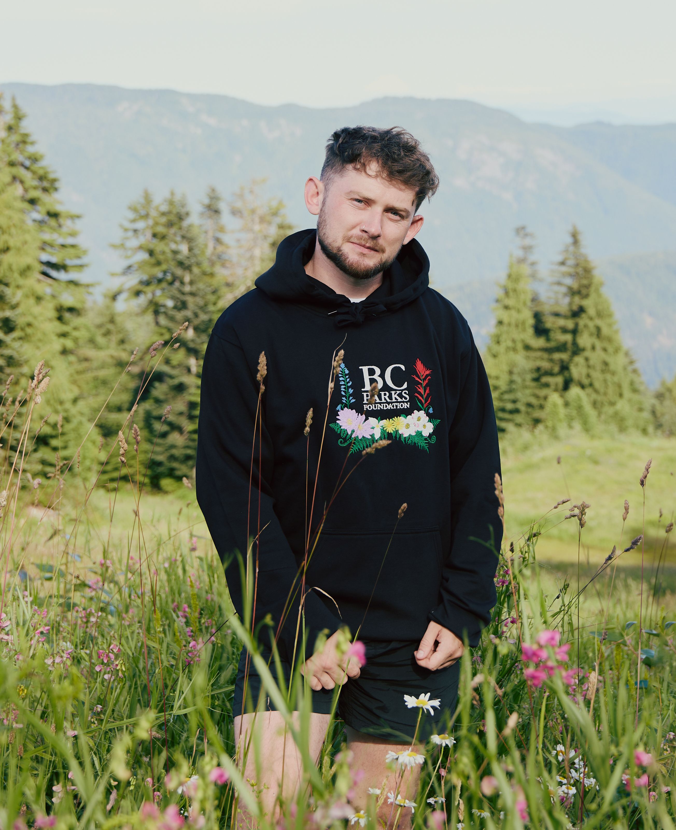 Person wears Wildflower hoodie in meadow
