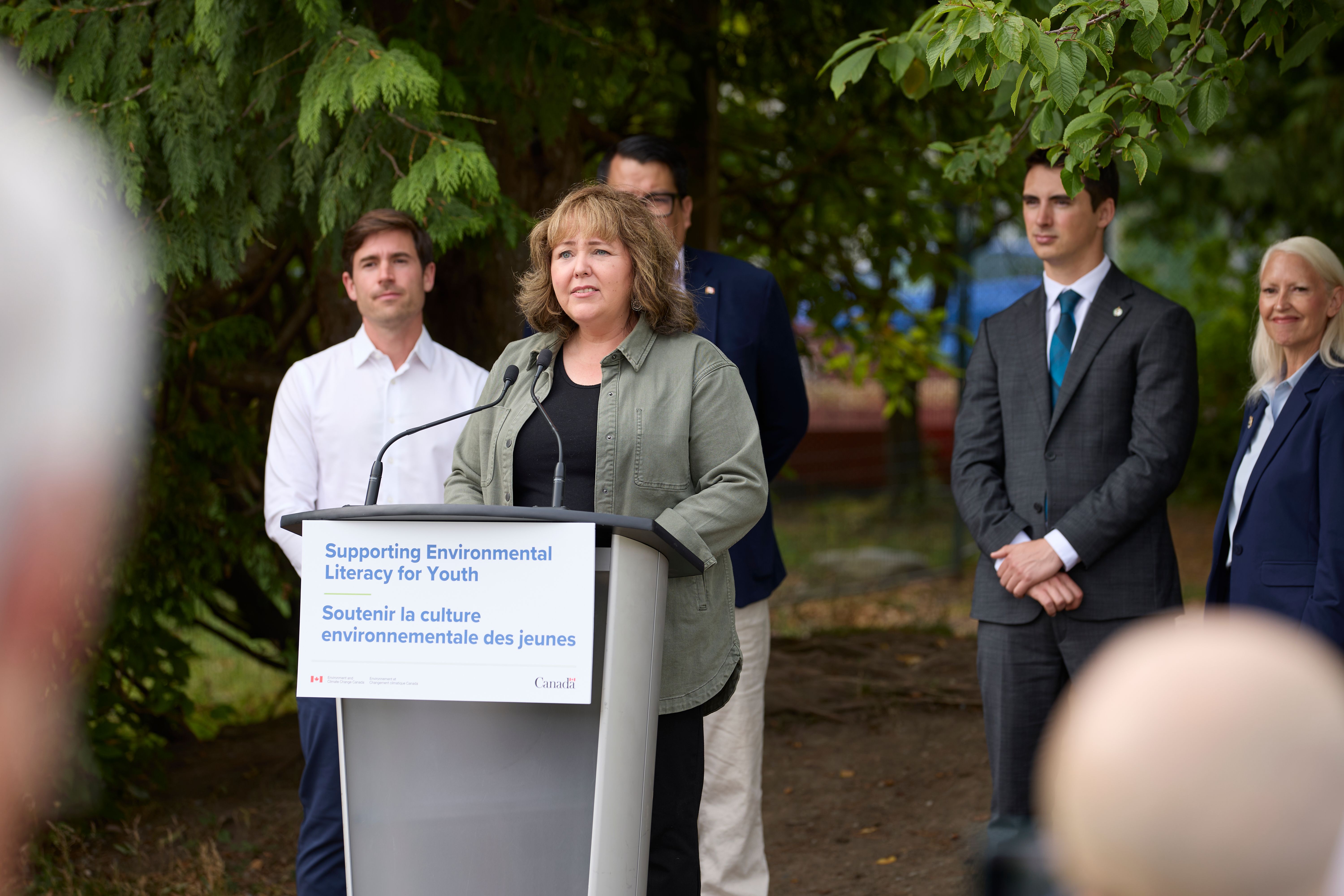 The Honourable Tamara Davidson talks at a podium.
