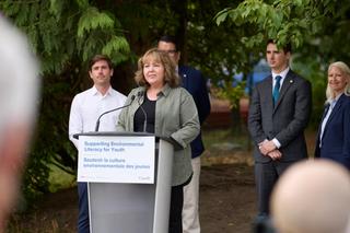 The Honourable Tamara Davidson talks at a podium.
