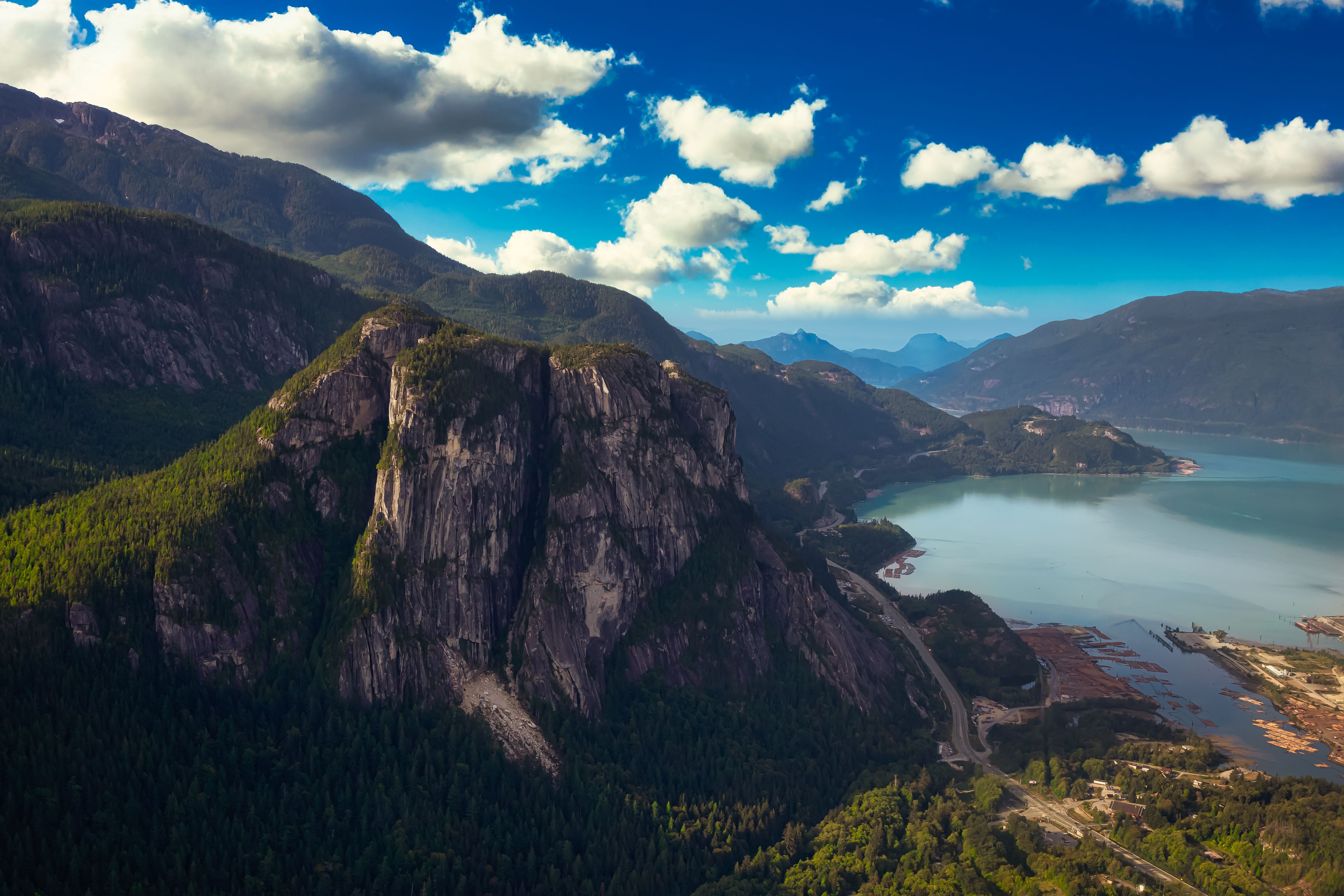 A large cliff face underneath a blue sky with dotted clouds