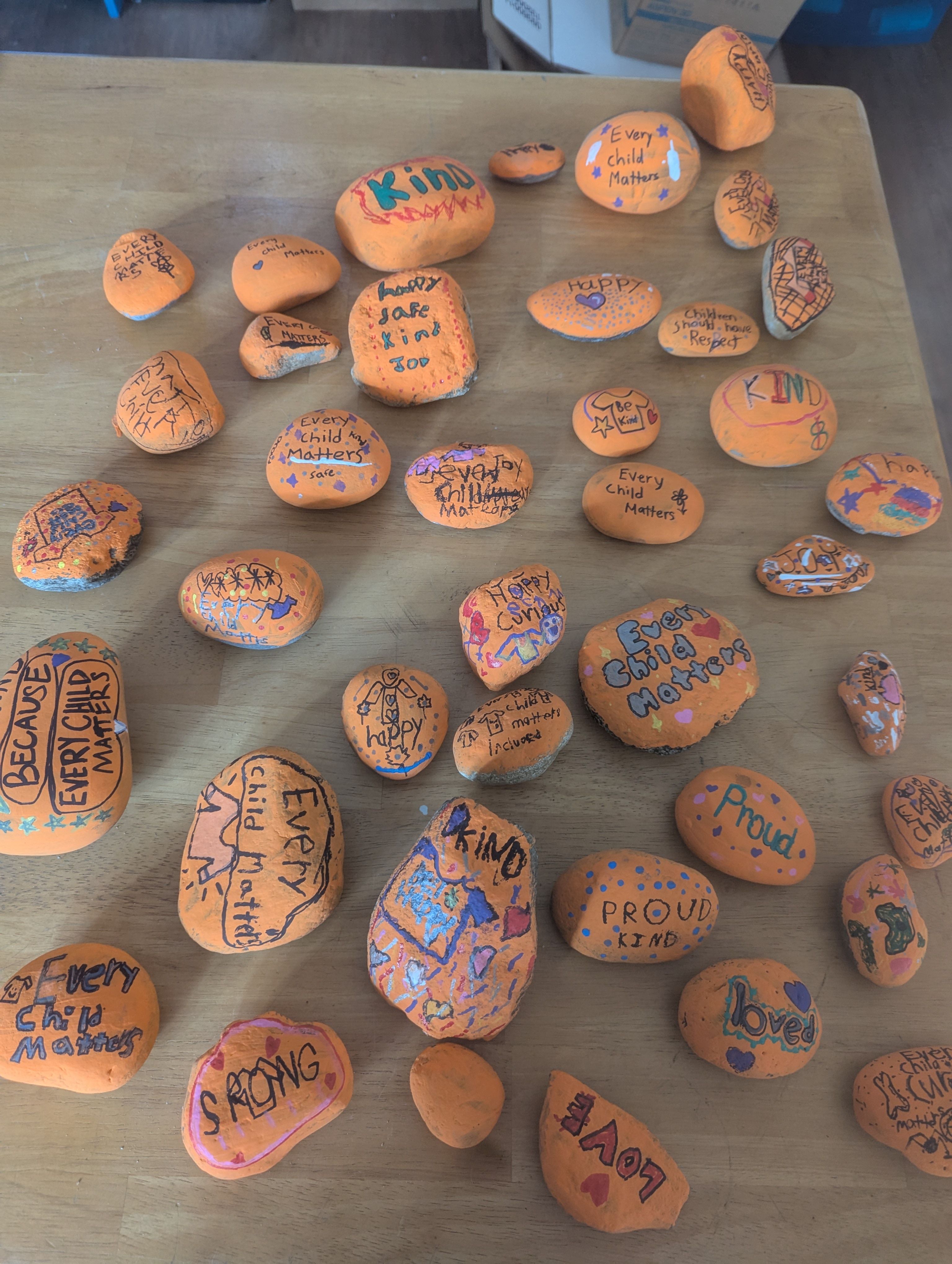 Painted rocks for Truth and Reconciliation, placed in a welcoming space beside the school garden where the whole community could pause and reflect. 