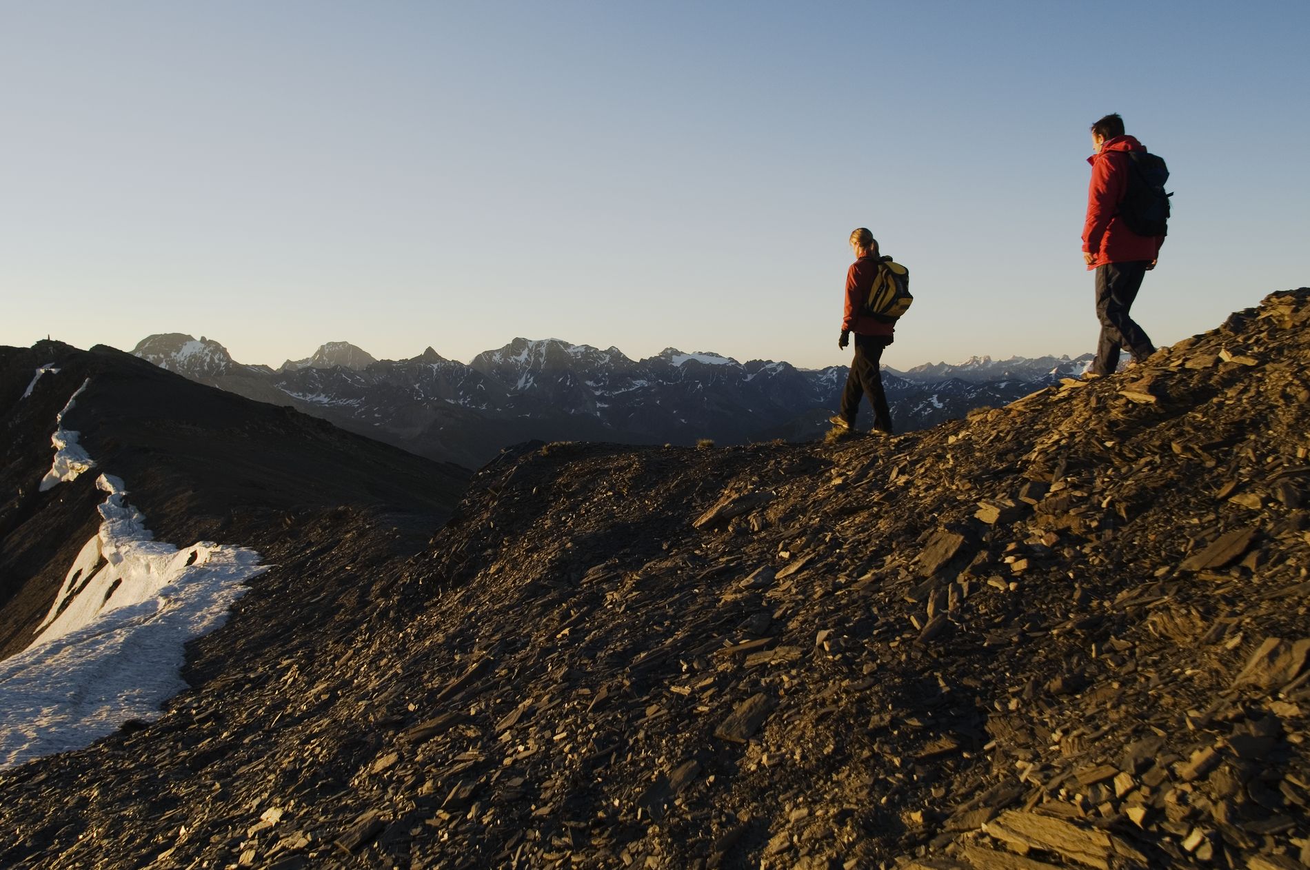 Two people traverse a rocky mountaintop