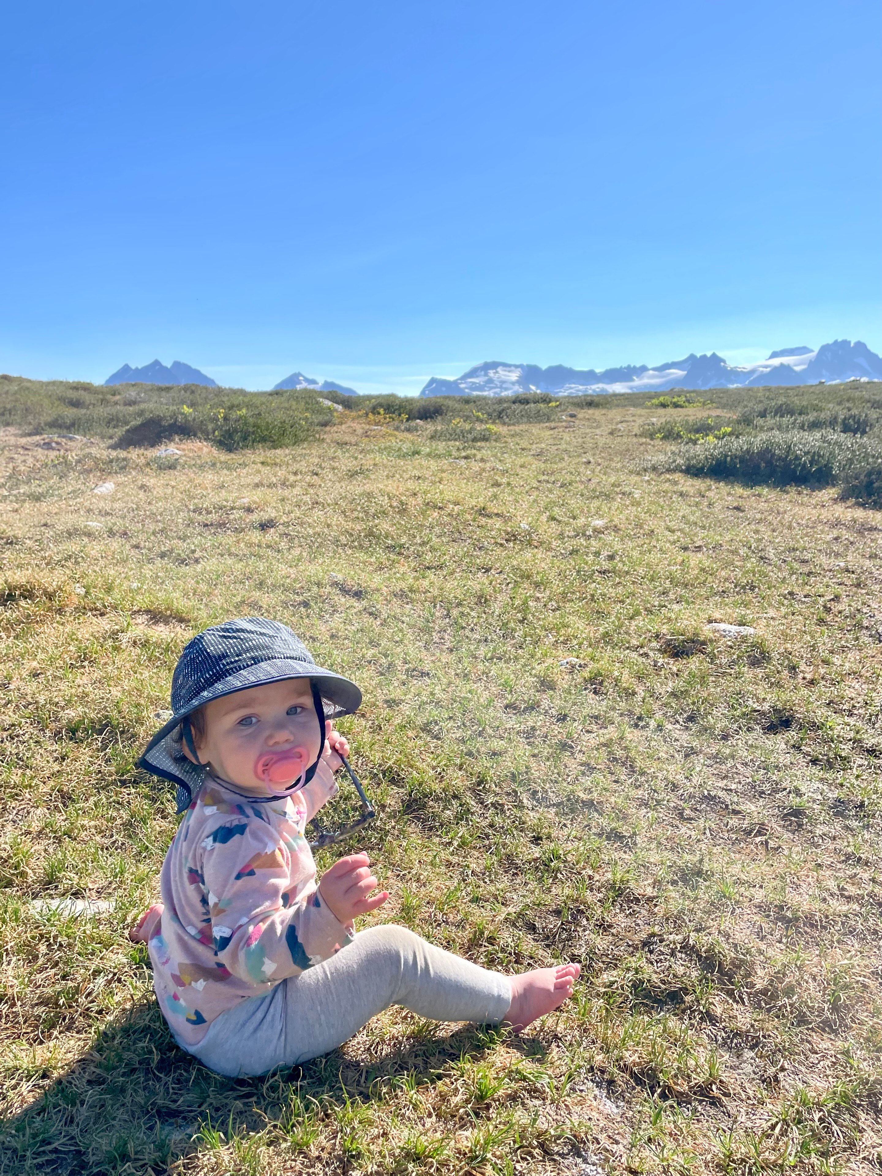 Child sits on grassy field