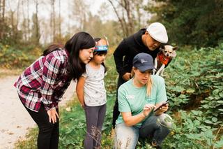 A volunteer speaks to a group of park visitors outdoors