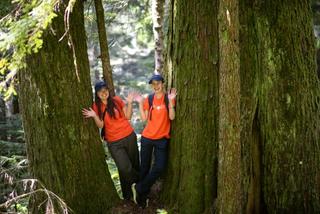 Two Discover Parks Ambassadors stand by a tree.