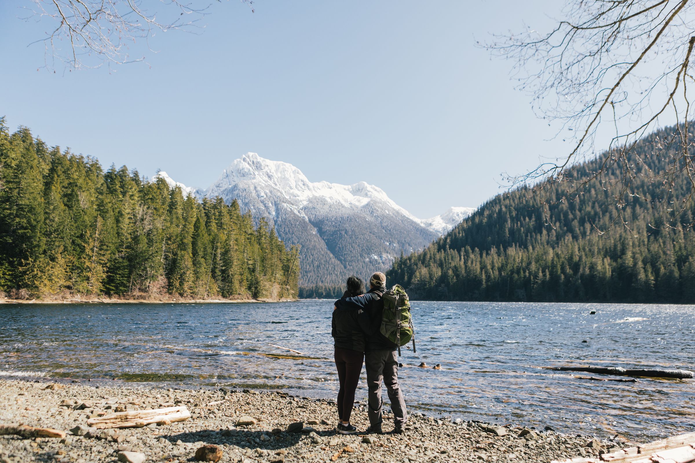 Two people looking out onto lake, mountains