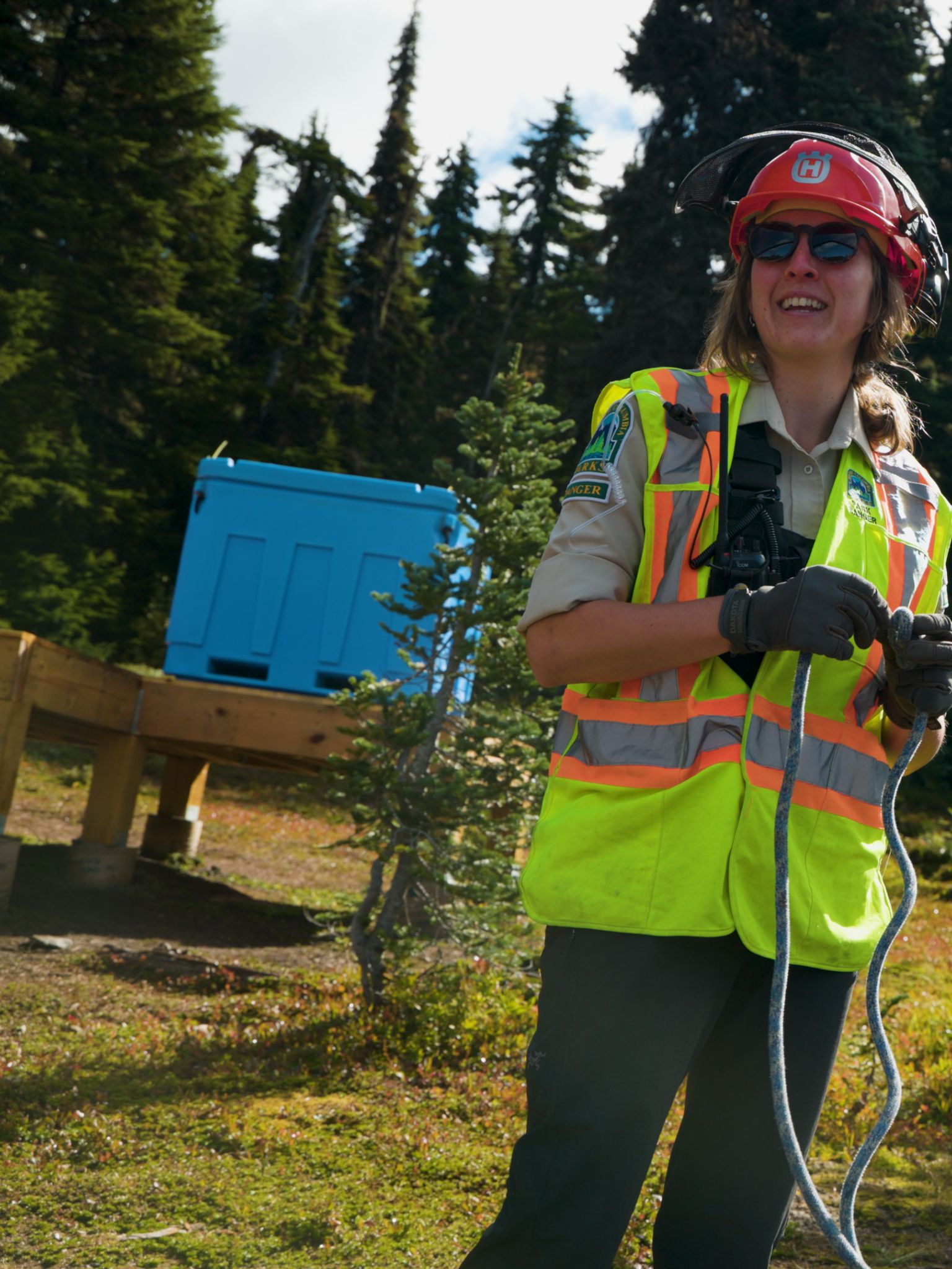 A smiling person in nature wearing protective gear