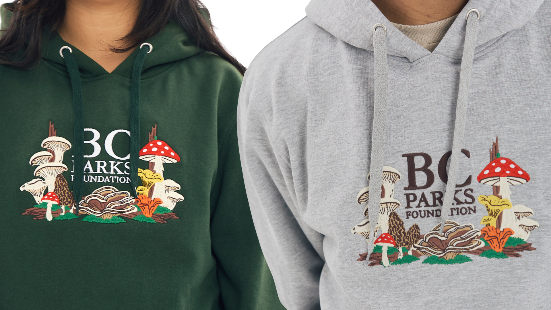 Two BC Wild Mushroom Embroidered hoodies, one in forest green and one in grey.