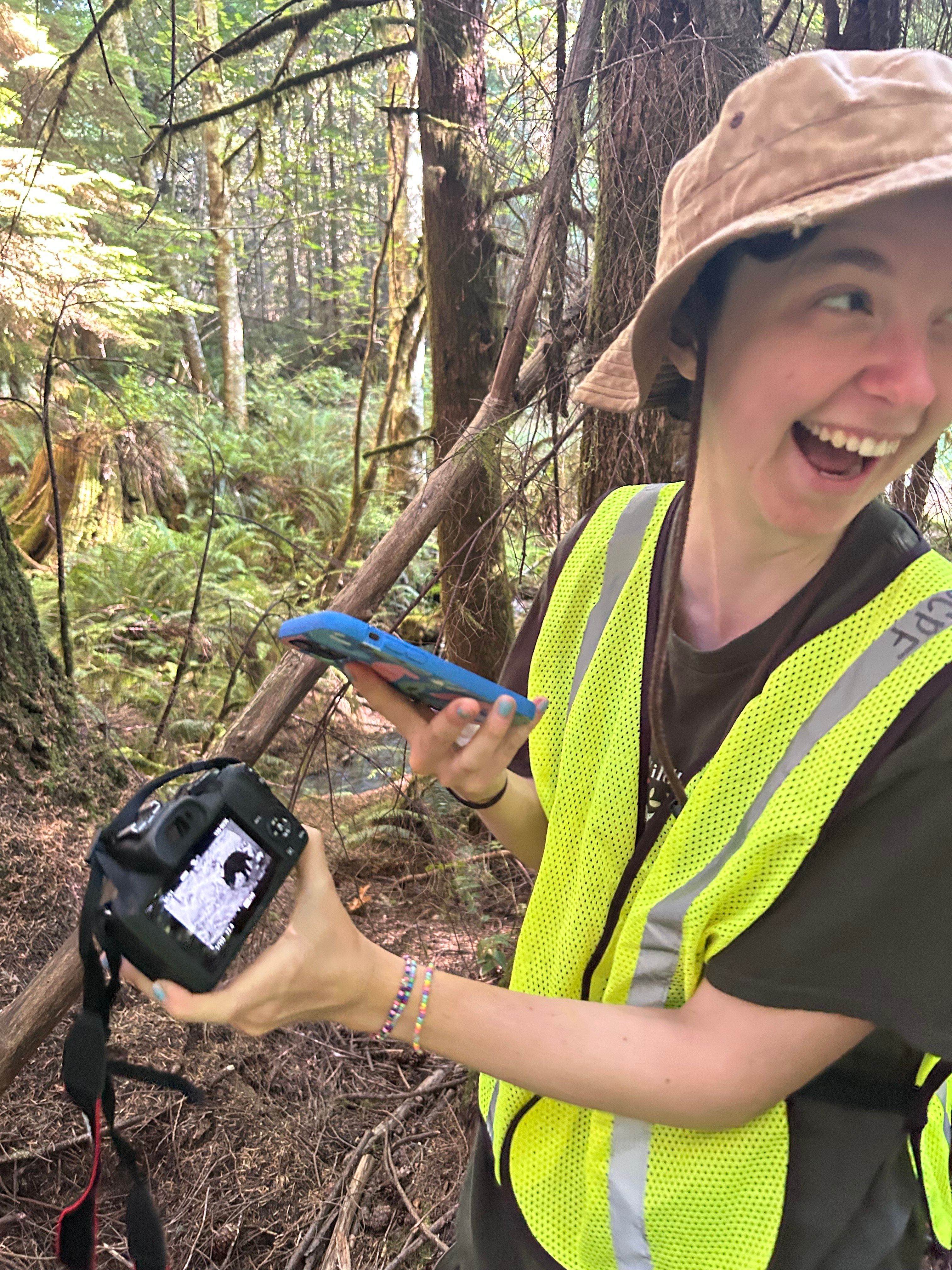 Climate Action Mobilizer Mya Johnson checks trail cam footage of a black bear—one of several species recorded at this site. These records contribute to long-term habitat monitoring. 