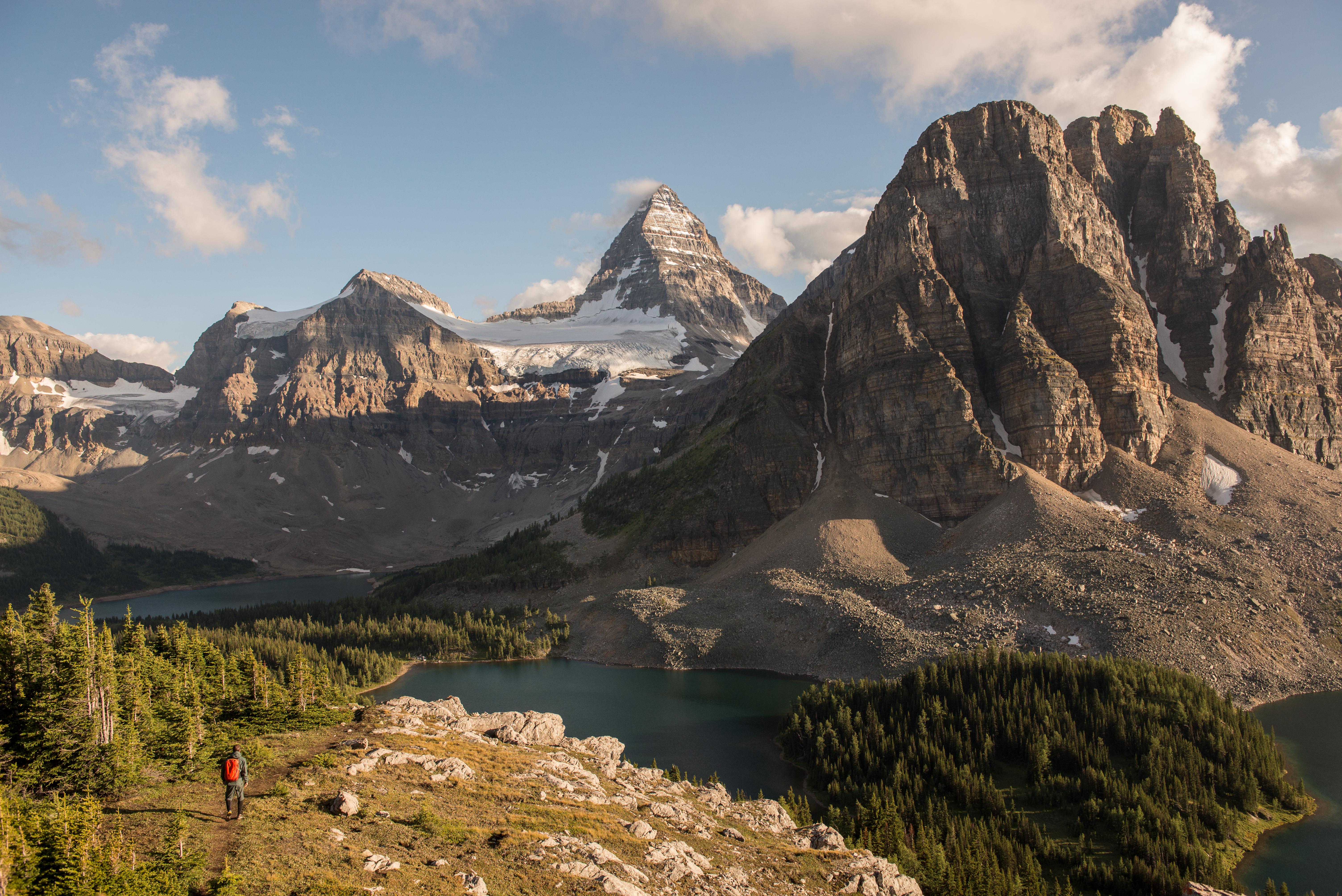 A shot of a lone hiker amongst snowcapped mountains