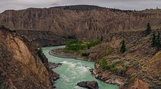An overview of a large mountainous valley with flowing rivers between