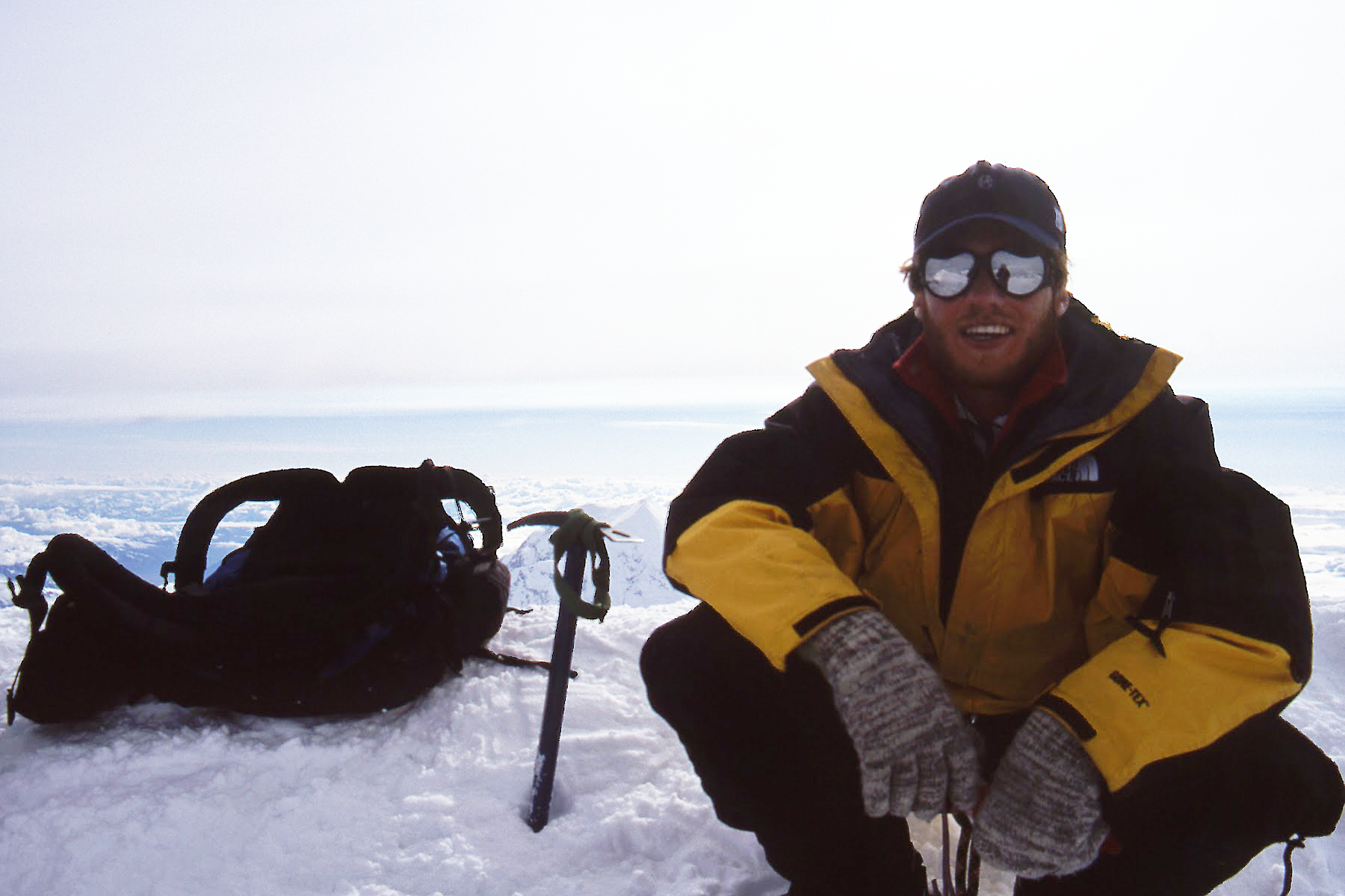 Jason McLean sitting in the snow near the summit