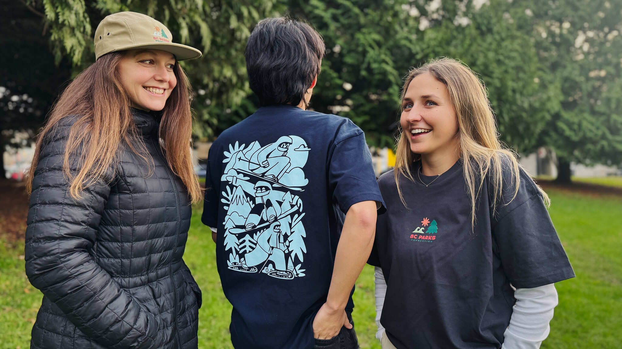 Three people wearing Turbo Bambi merch pose for camera in park