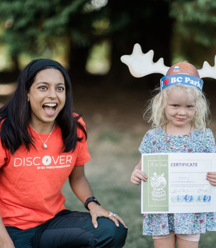 A Discover Parks Ambassador celebrates a child's completion of a Discover Parks program