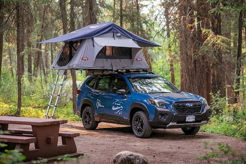 Subaru with roof tent in forest