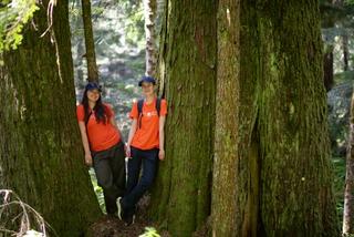 Two Discover Parks Ambassadors stand by a tree.