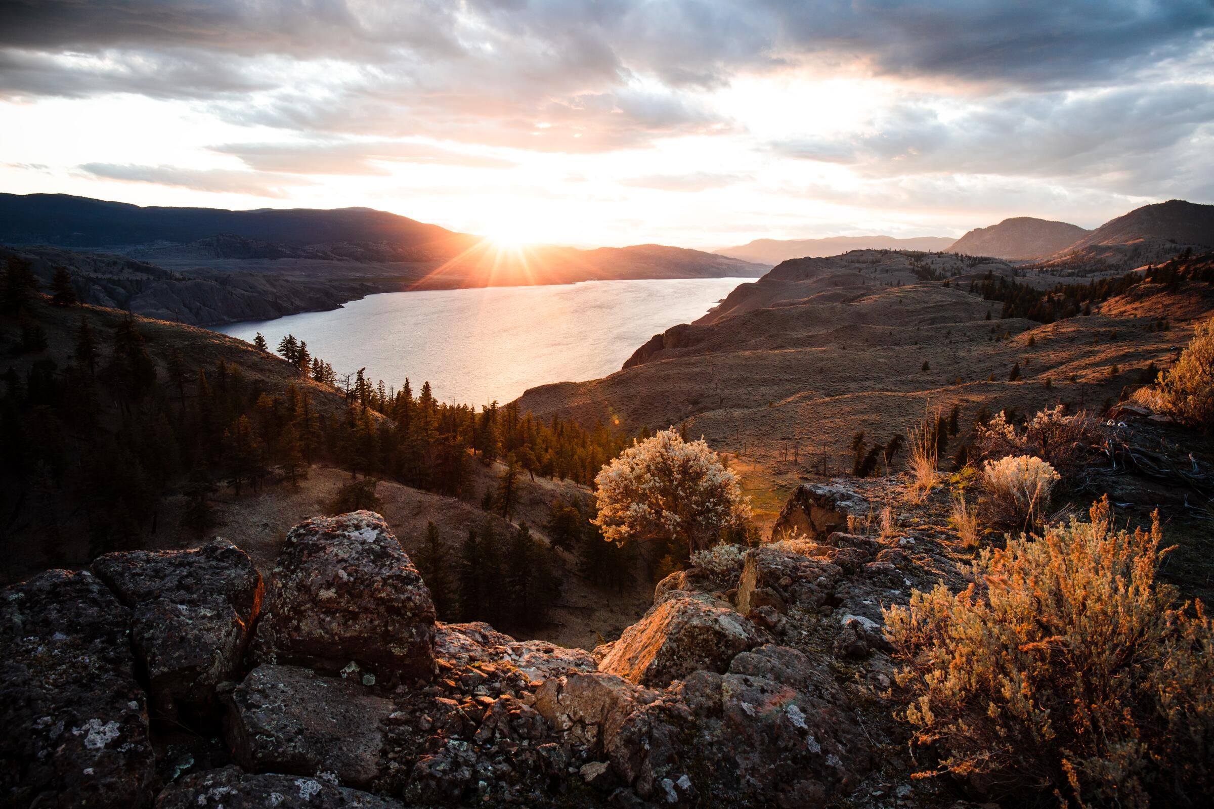 Sunset over a valley lake near Kamloops, seen from a rocky ridge.