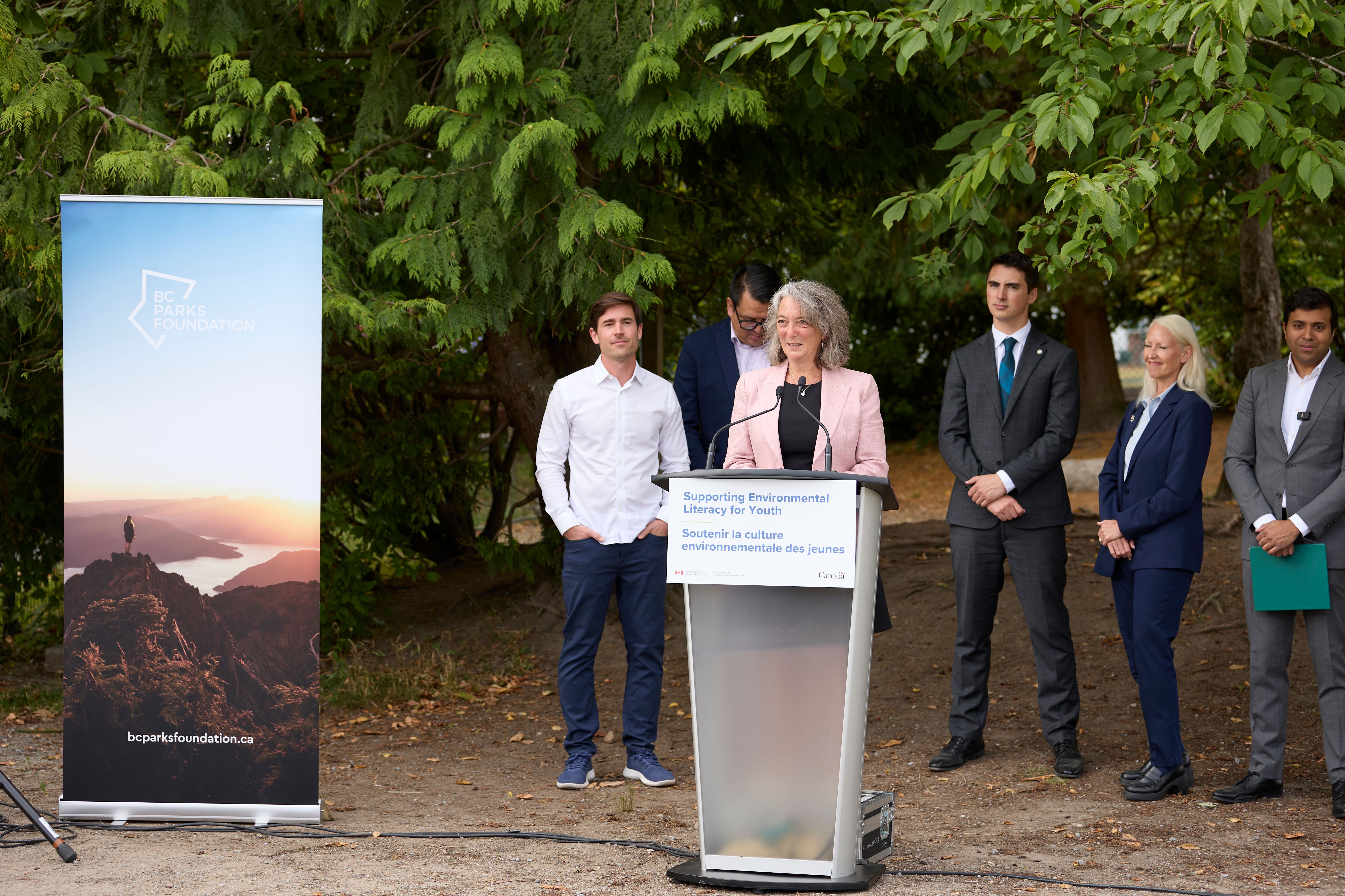 The Honourable Julie Dabrusin speaks behind a podium.