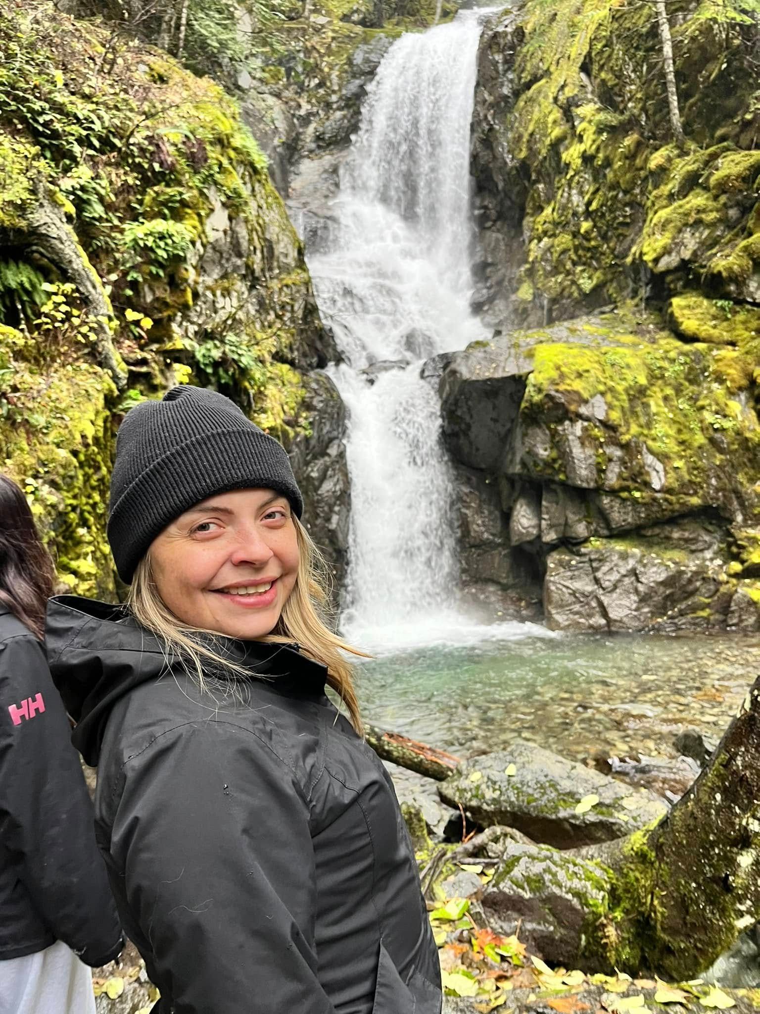 Hiker takes picture with waterfall