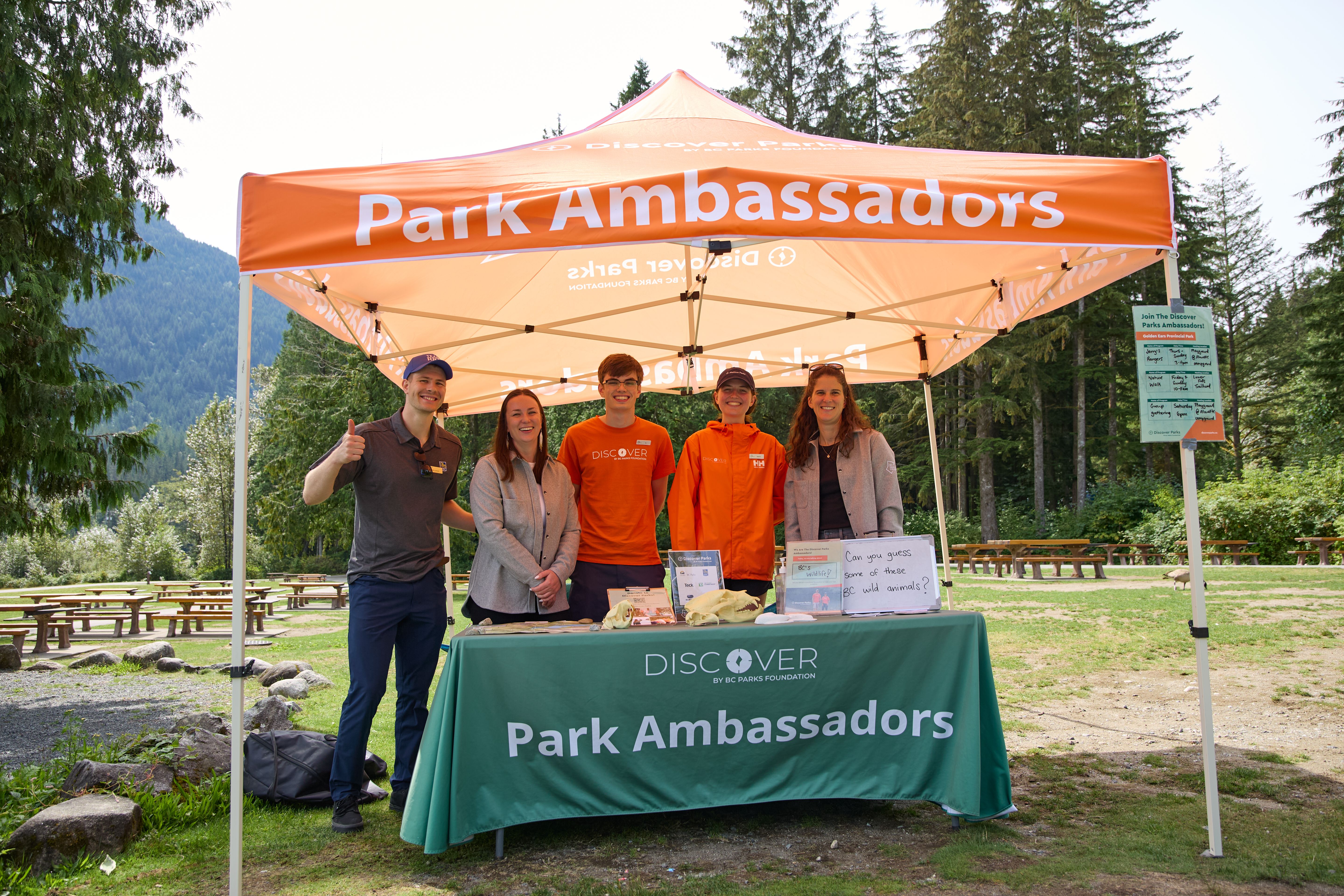 A group of people pose for a photo at a Discover Parks booth