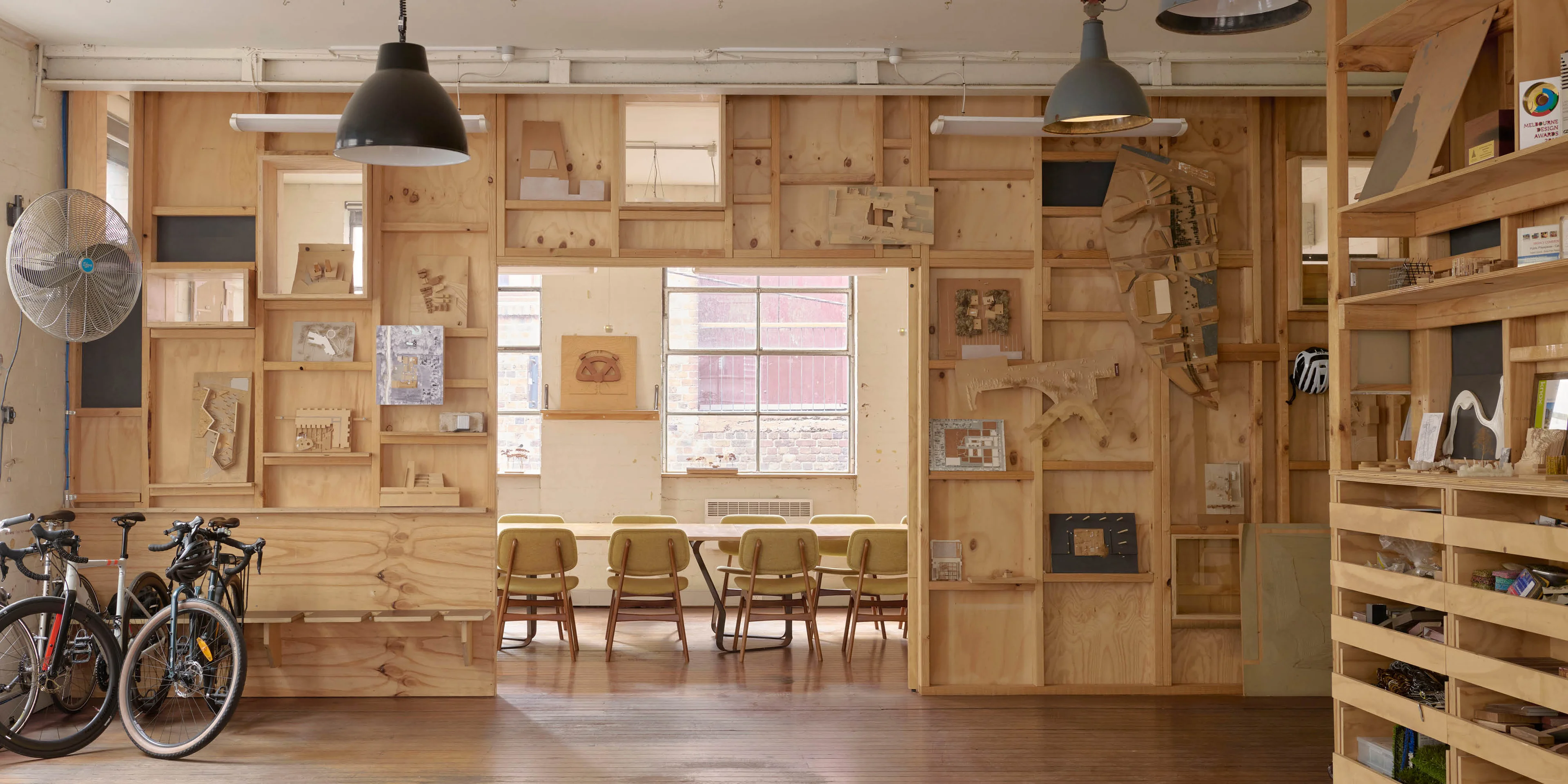 Plywood walls contain model designs, with bikes sitting in the corner of the room.