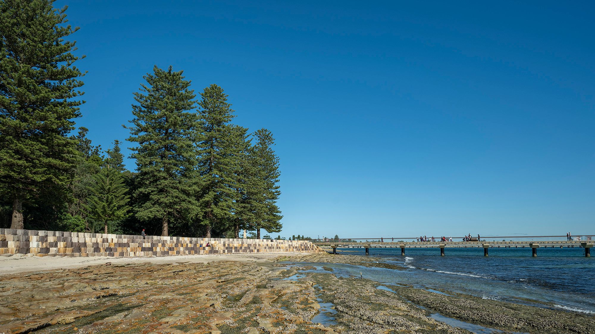 Revetment wall shown alongside bridge stretching into the bay.