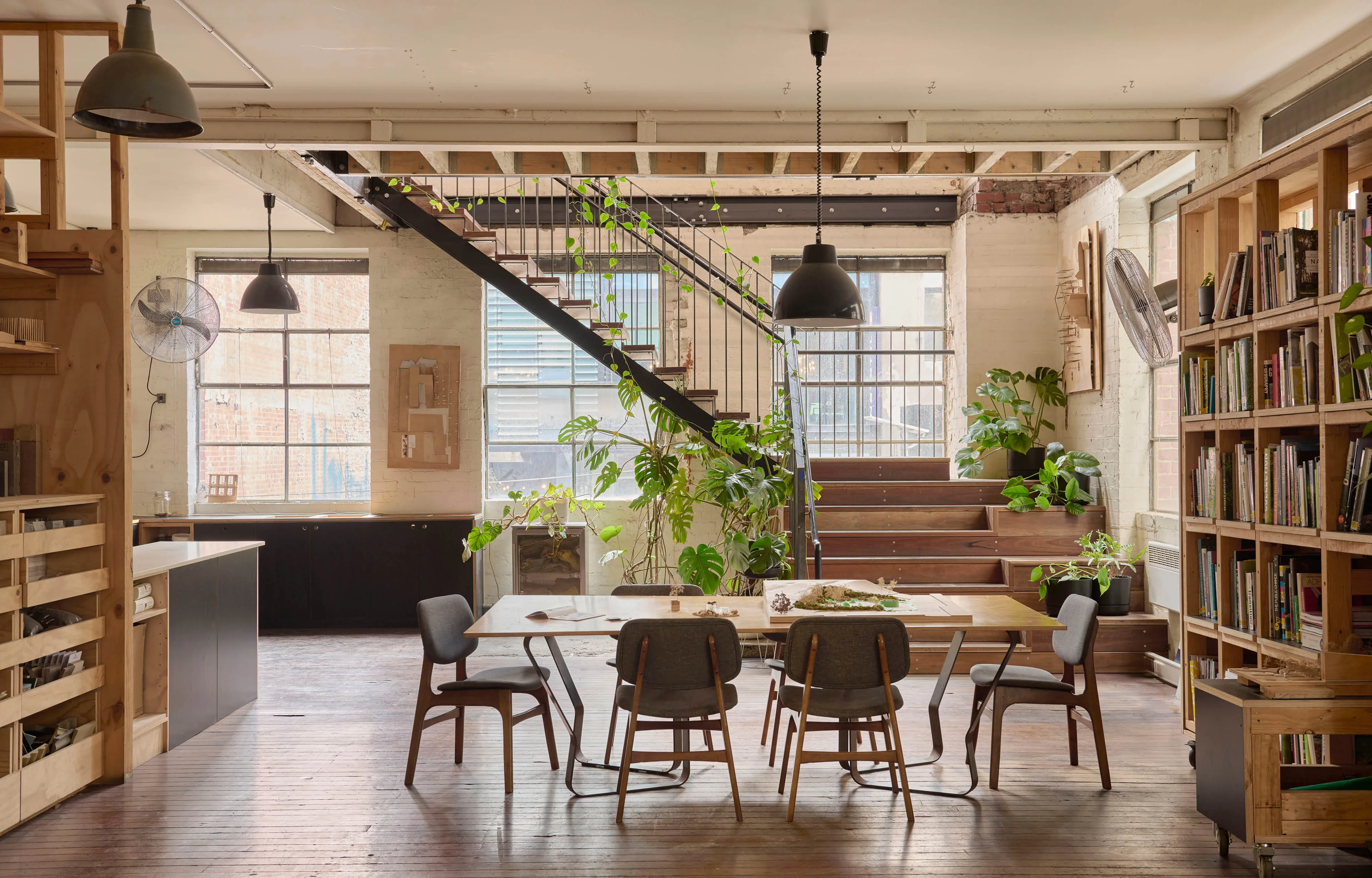 Large meeting room with table, chairs, bookshelves and large windows.