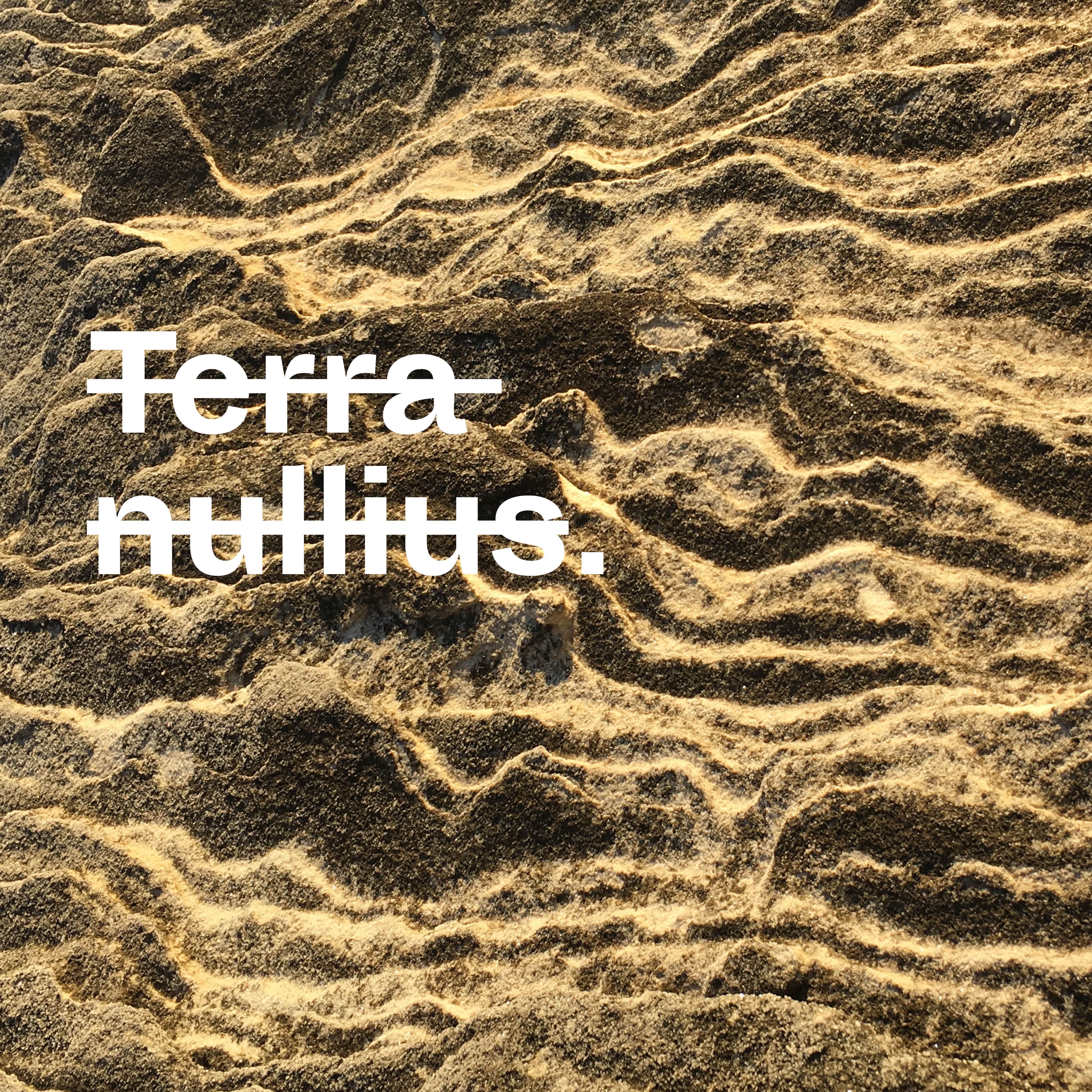 Photograph of undulating sandstone, with white text, crossed out, that reads 'terra nullius.'