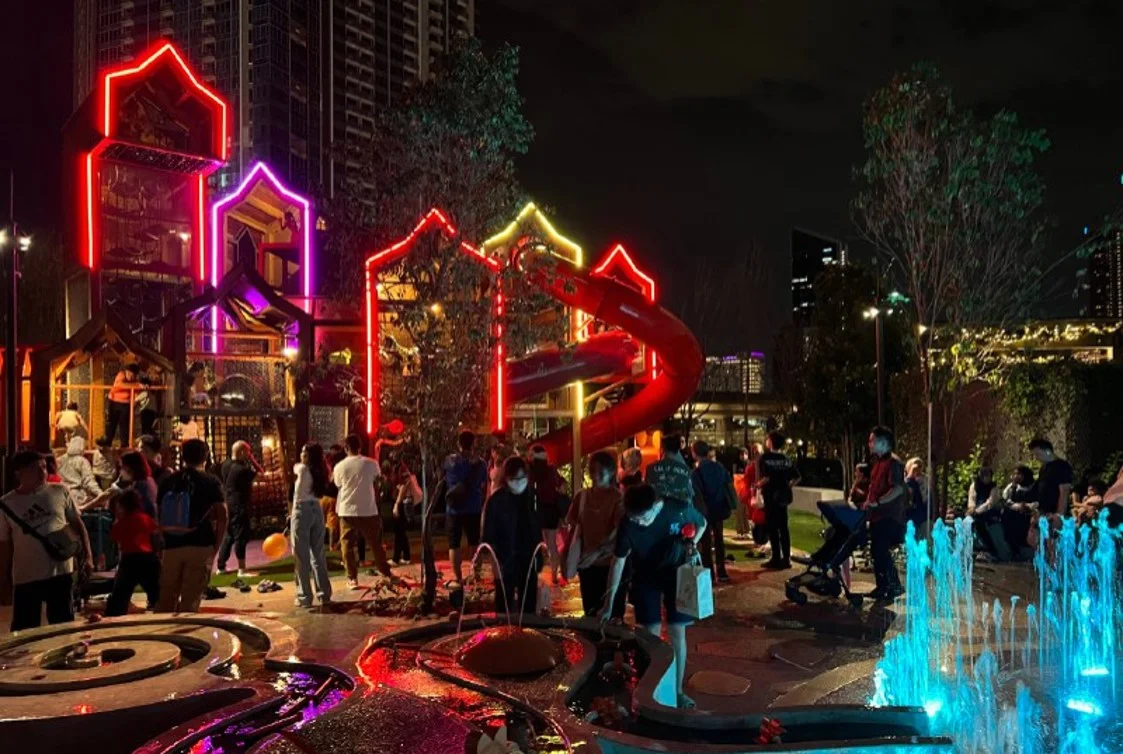 A photograph of a busy urban playspace lit up at night.