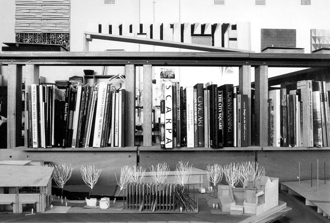 A black and white photograph of a bookshelf of landscape architecture books and models.
