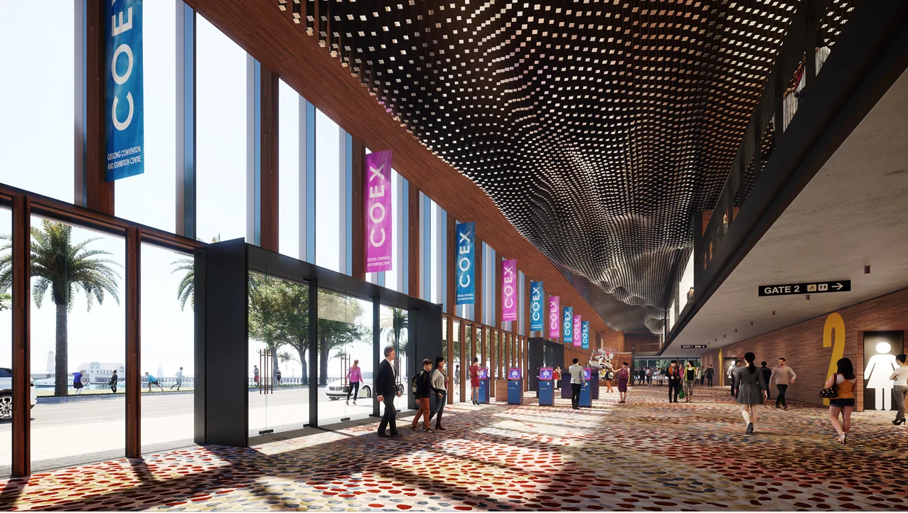 A 3D computer render of the entry space of a large building. There is a large wall of glass windows and doors to the left, with views to the waterfront landscape. Blue and Pink Flags as seen on the windows, and people are moving about in the distance.