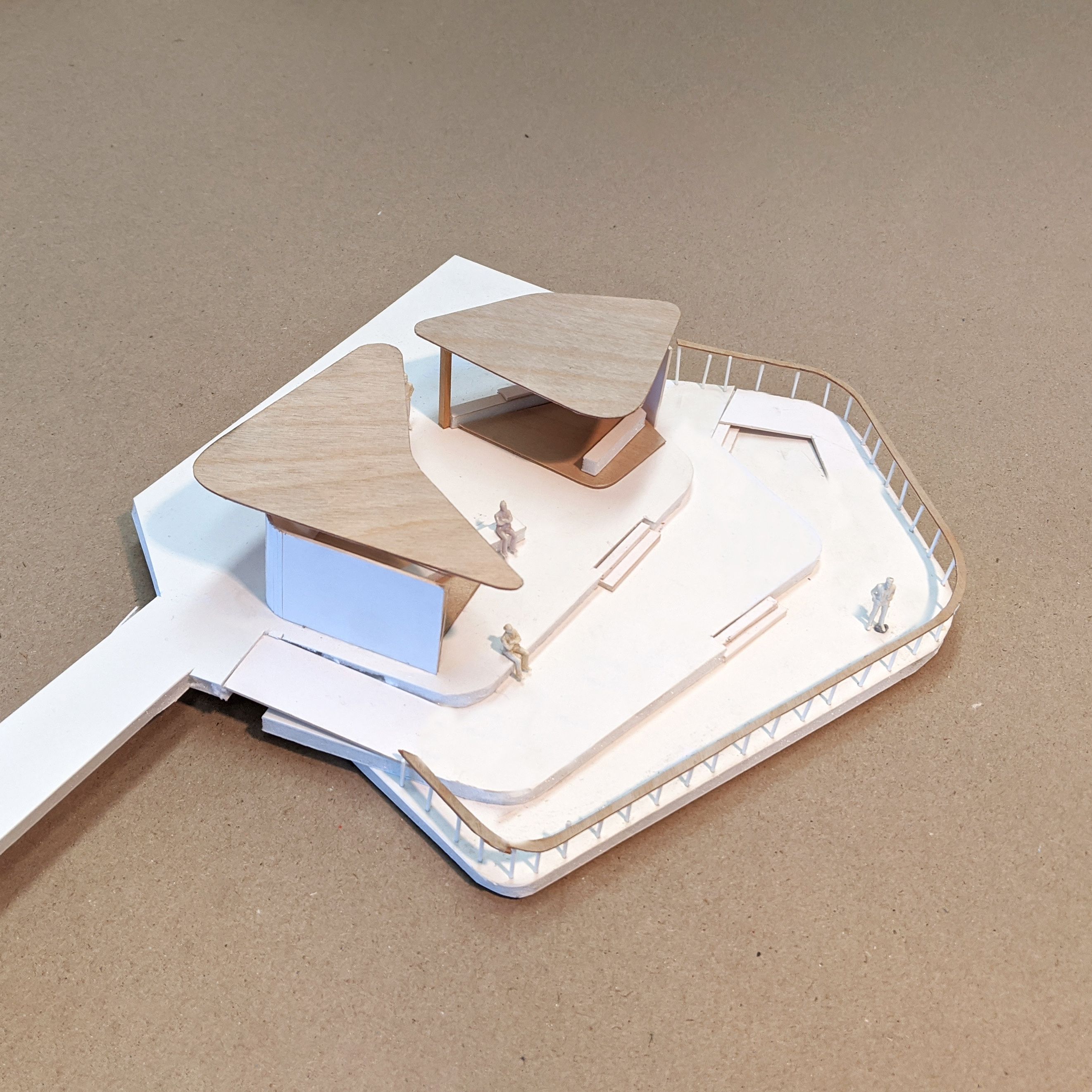 A photograph of a cardboard model of outdoor shelters comprised of stacked organic shapes.