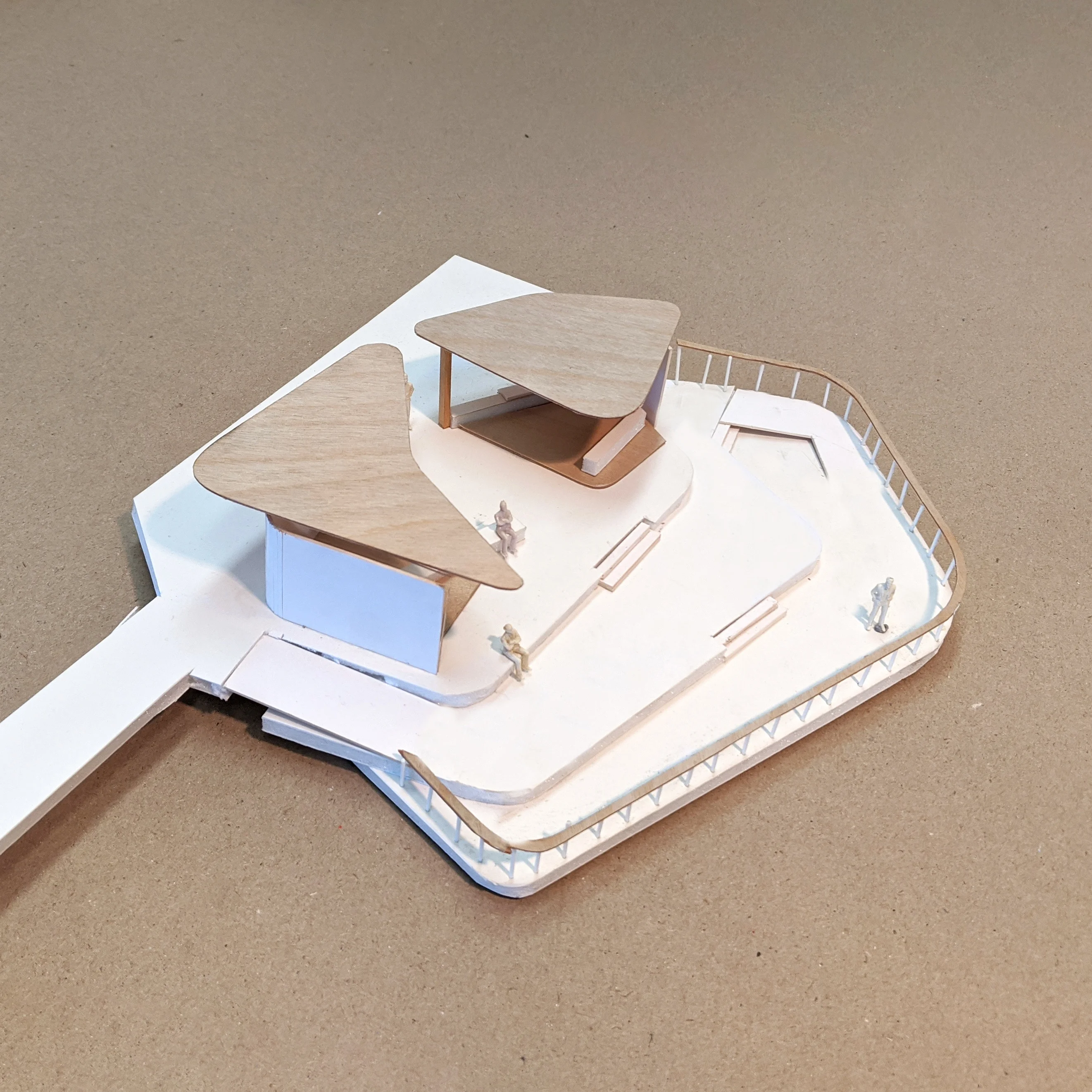 A photograph of a cardboard model of outdoor shelters comprised of stacked organic shapes.