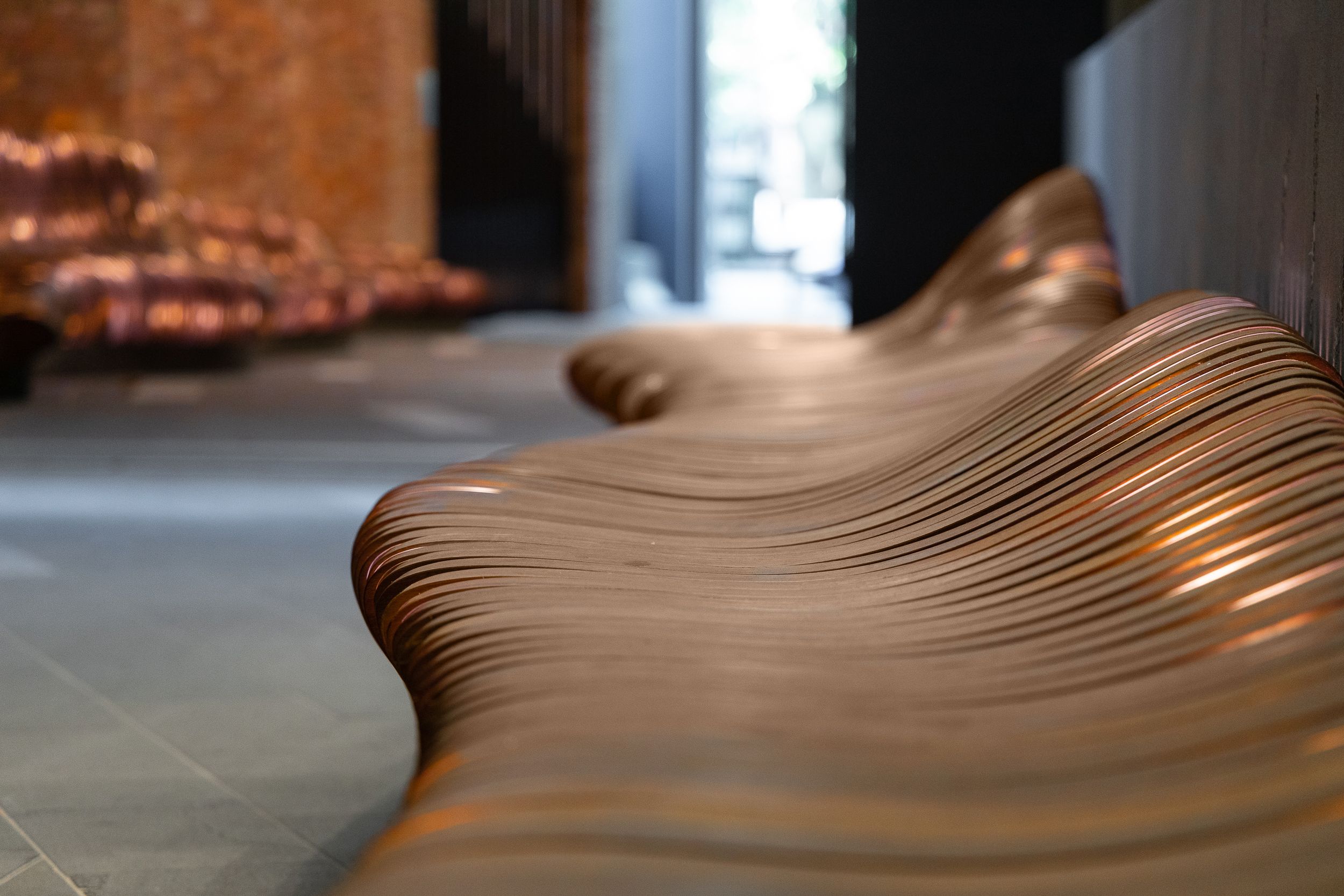 A close-up photo of a sinuous timber bench seat.