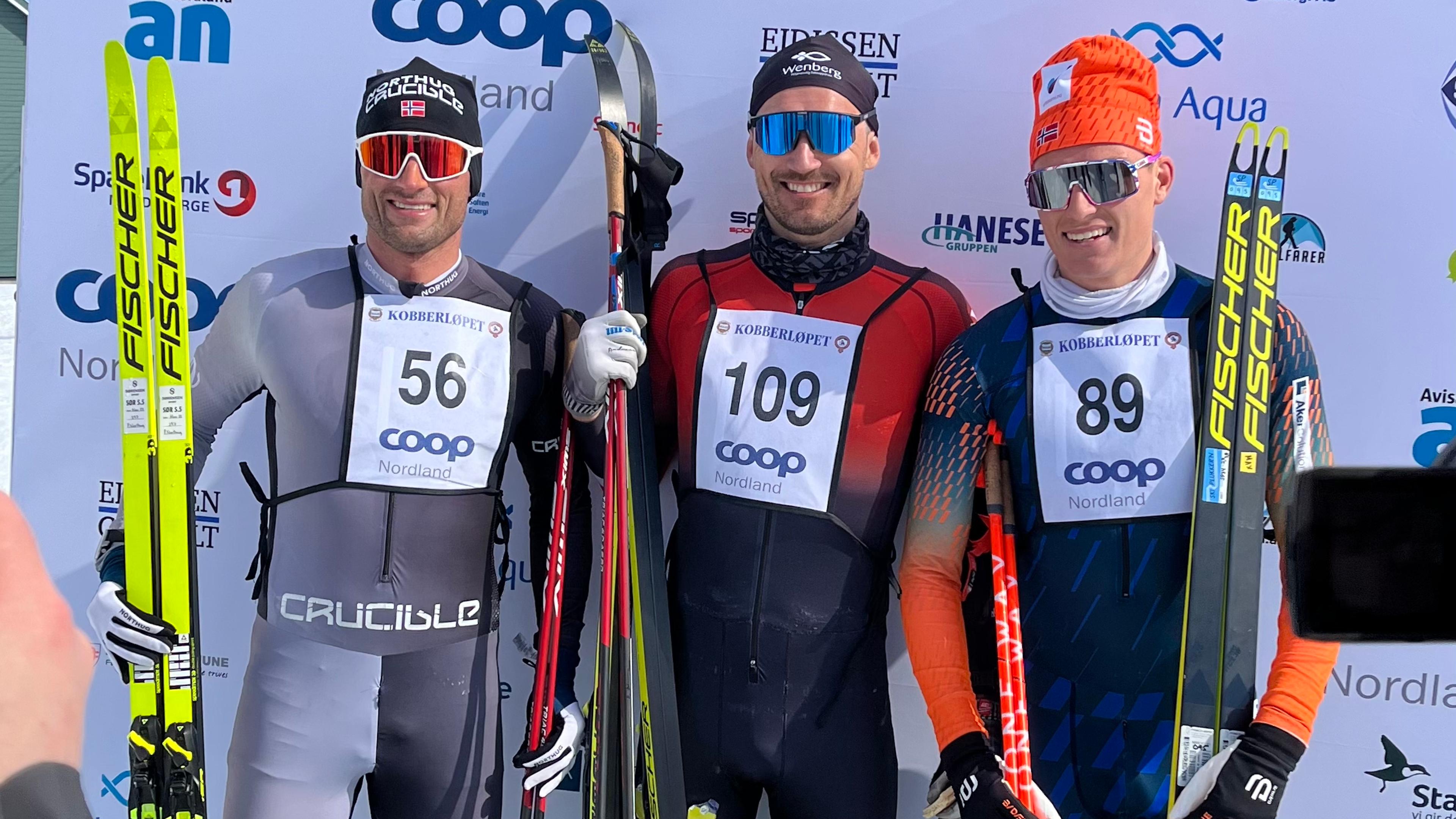 Petter Northug, Andreas Nygaard og Vebjørn Moen står foran pressevegg. De har alle startnummer på og skiene i hendene etter å ha kommet i mål i Kobberløpet 2023.