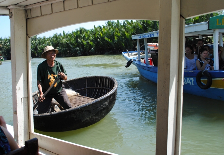 en mann sitter i en rund båt på en elv