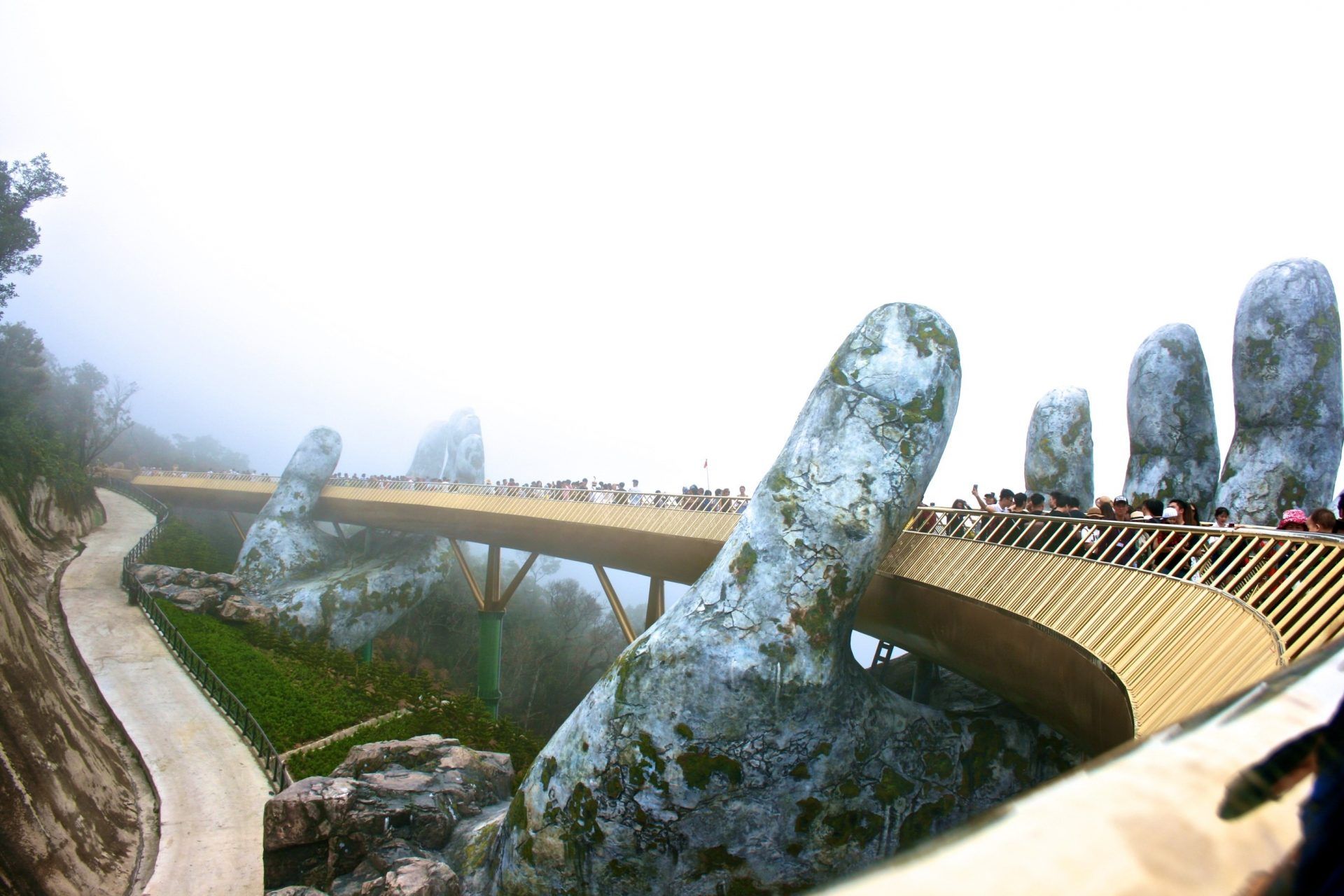 en grupp människor går över en bro som ser ut som en hand.