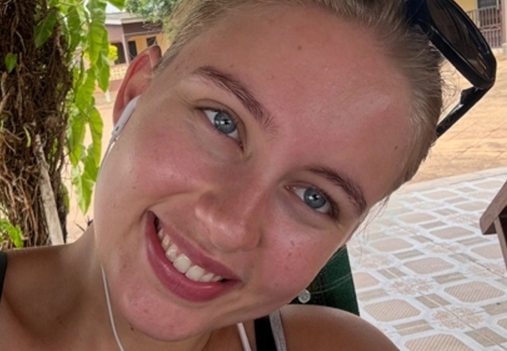 a woman wearing headphones and sunglasses smiles for the camera