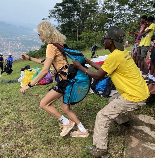 a man in a yellow shirt is helping a woman carry a blue bag