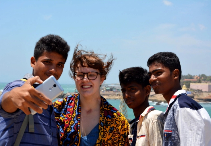 a group of young people are taking a selfie with a cell phone .