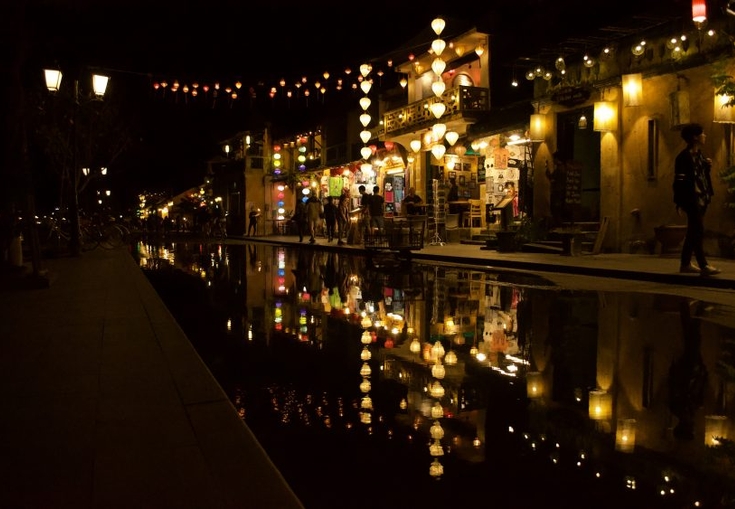 en grupp människor går nerför en gata på natten