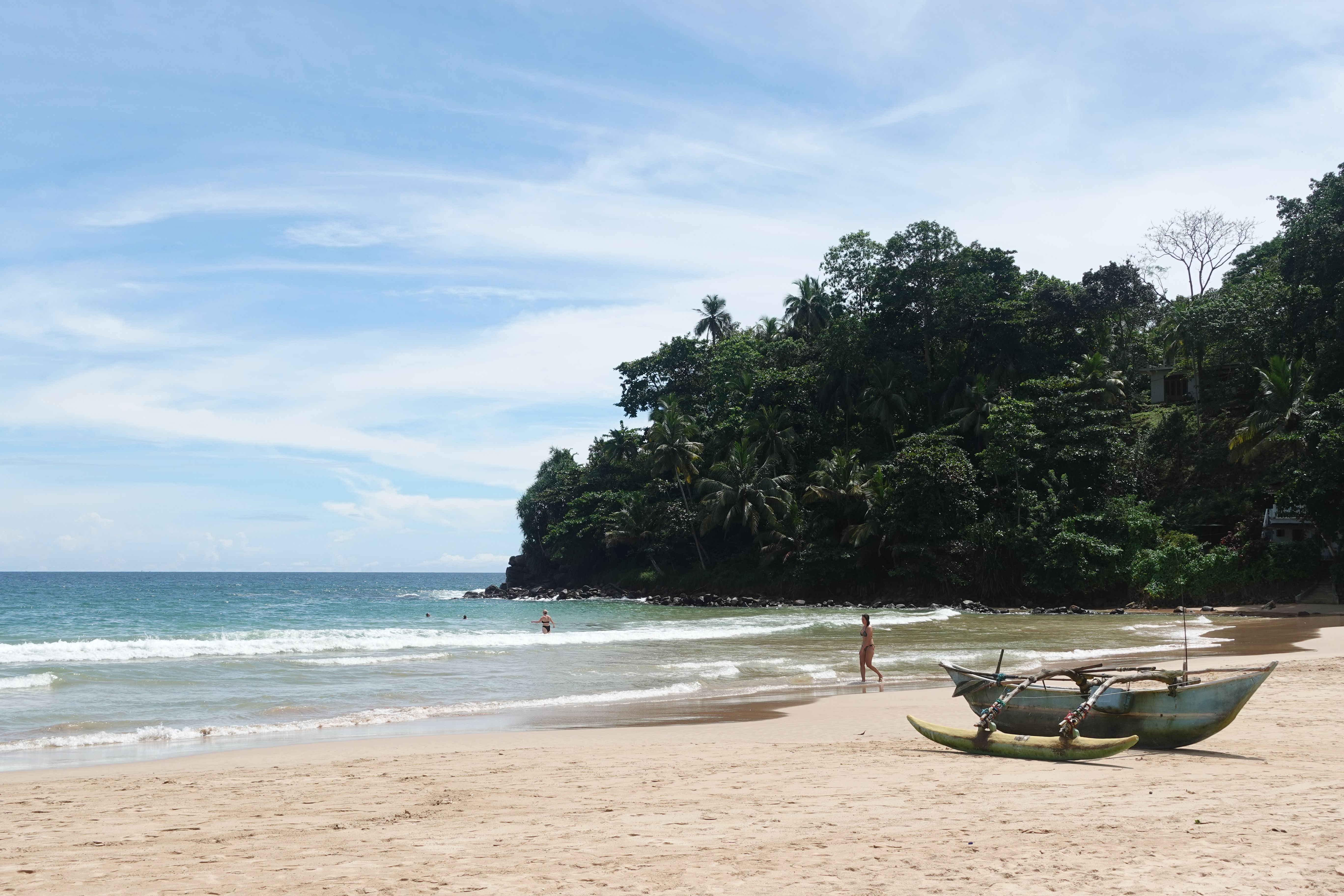 a couple of boats are sitting on the beach next to the ocean .
