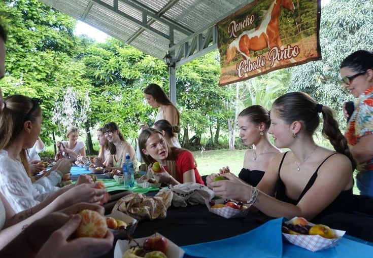 a group of people are sitting at a table eating food .