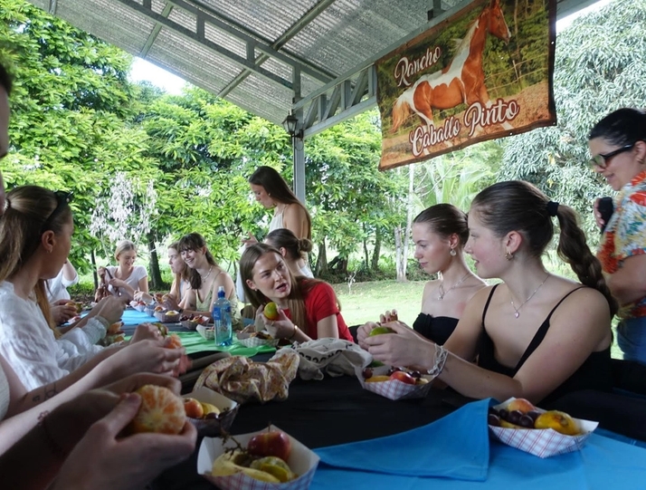a group of people are sitting at a table eating food .