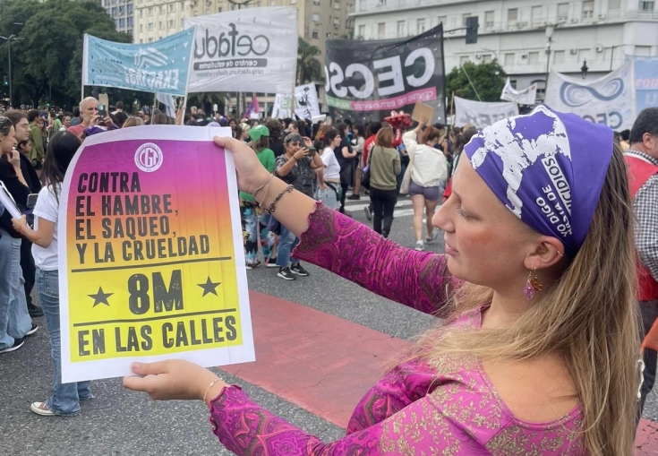 a woman is holding a sign at a protest .